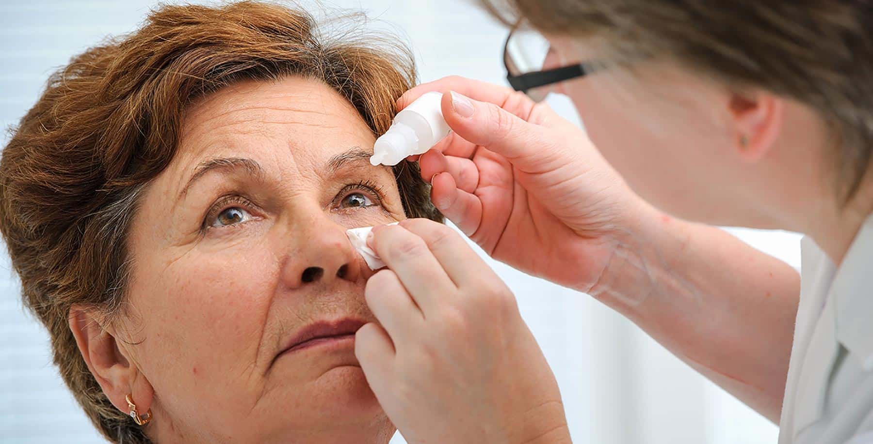 Лечение катаракты без операции у пожилых. Закапывая капли в глаза пациенту. Осмотр глаз. Аппликационная терапия глаза.