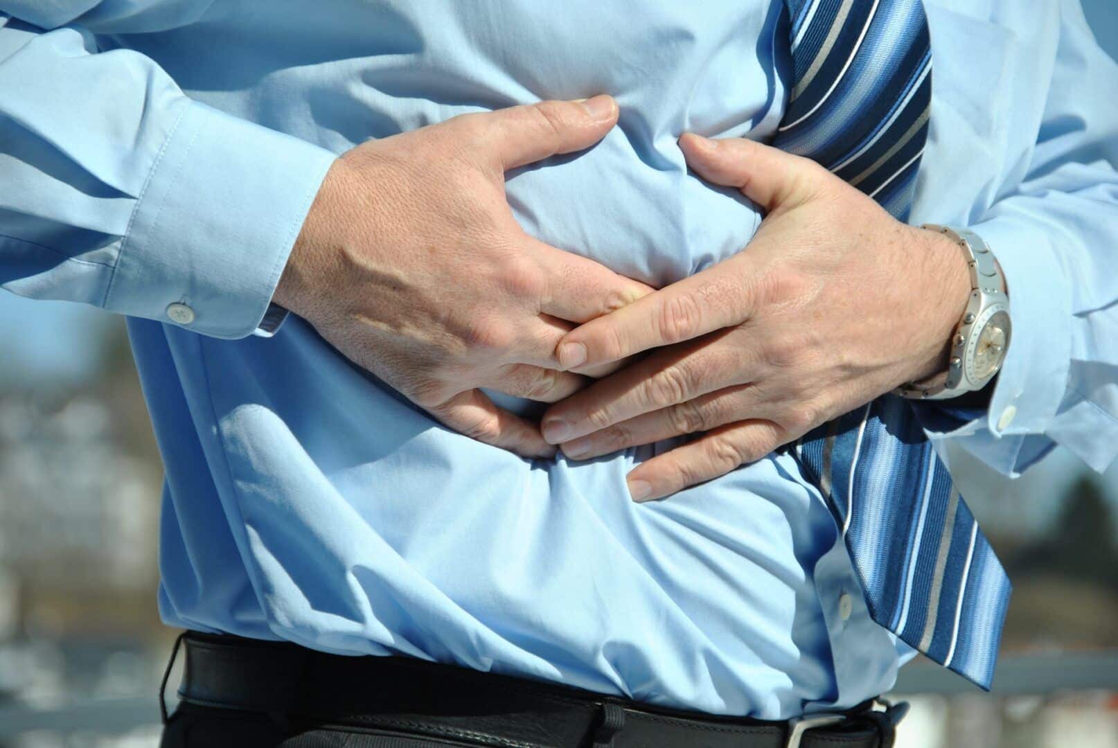 Fotografia de um homem com dor na barriga para ilustração do item