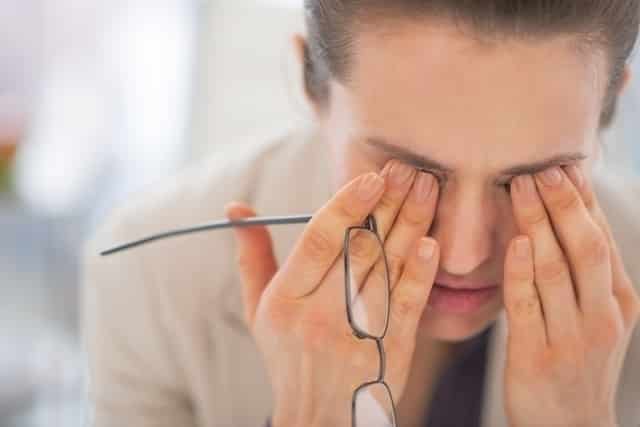 Fotografia de uma mulher com mãos nos olhos